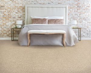 A modern bed in a room with a brick wall background and beige carpet