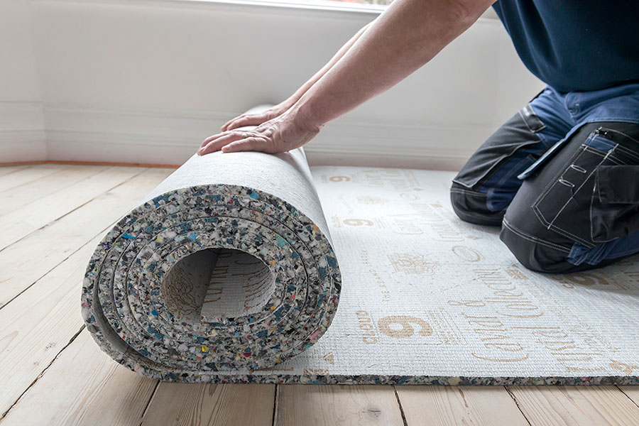 An image of carpet underpad being rolled out before installation.