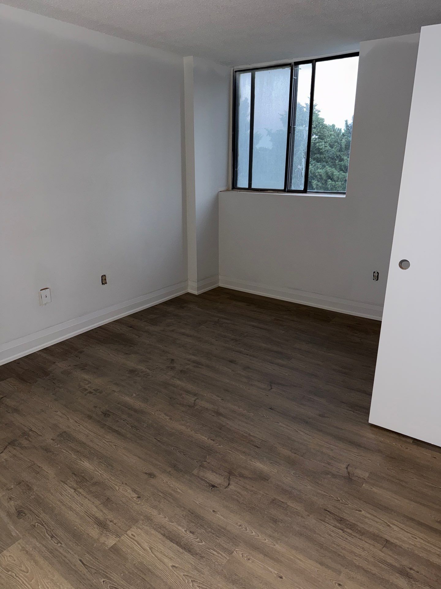 SmartDrop 7 Cashmere luxury vinyl flooring installed in a condominium bedroom